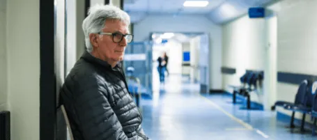 A man sitting in a hospital corridor