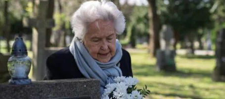Image of lady paying respects at grave