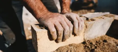 image of hands on bricks